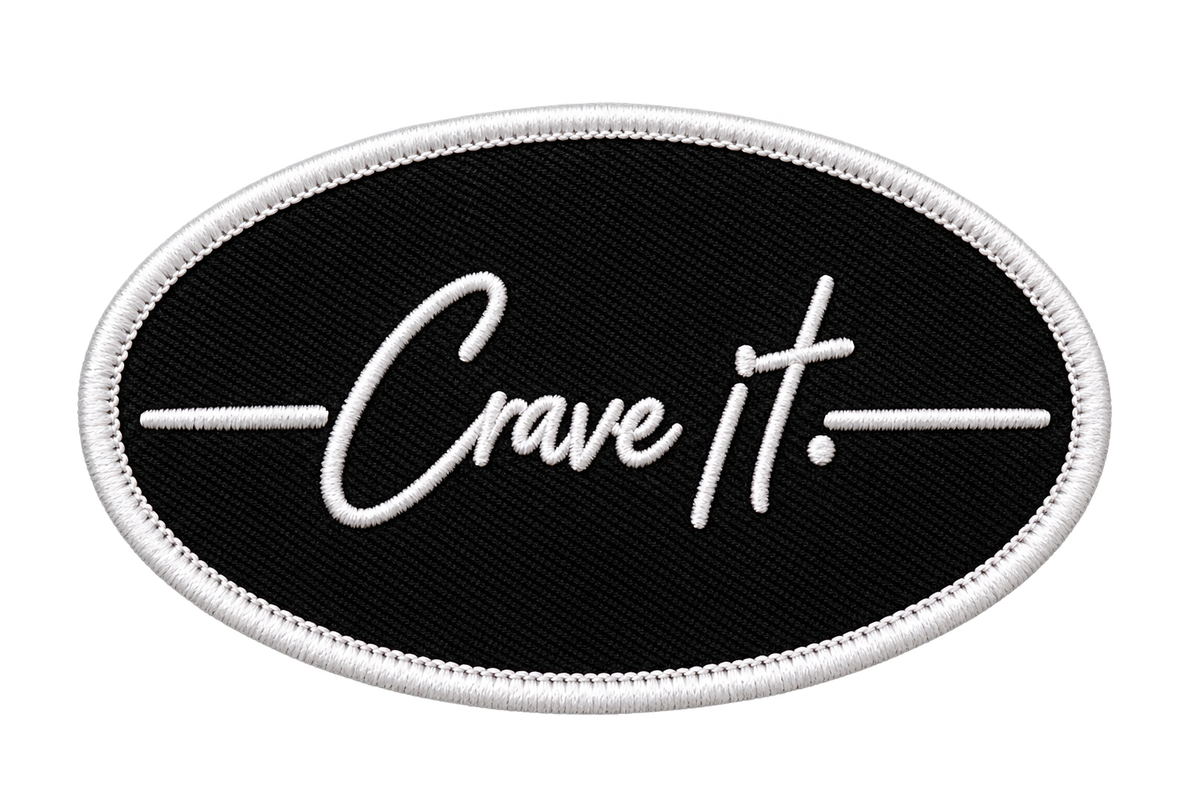 Black oval Crave it. stick-on patch with white embroidered border on a clean white background