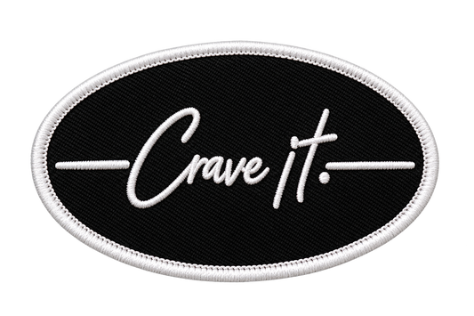 Black oval Crave it. stick-on patch with white embroidered border on a clean white background